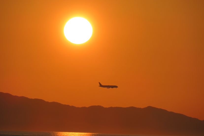 夕陽の下を飛ぶ飛行機