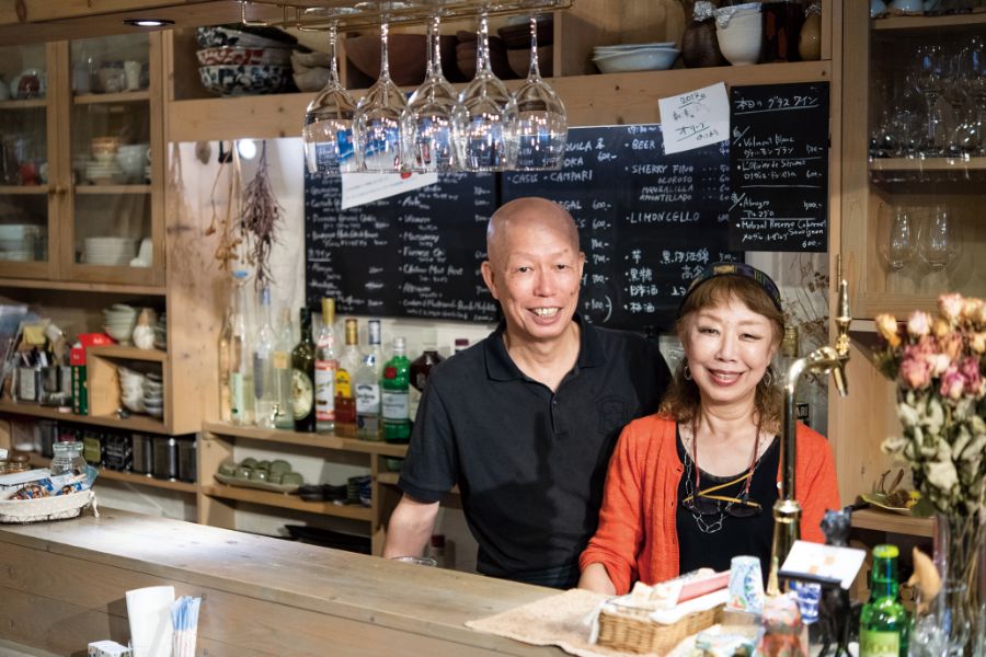 店のカウンターでほほ笑む田中隆夫さん 明美さんご夫妻