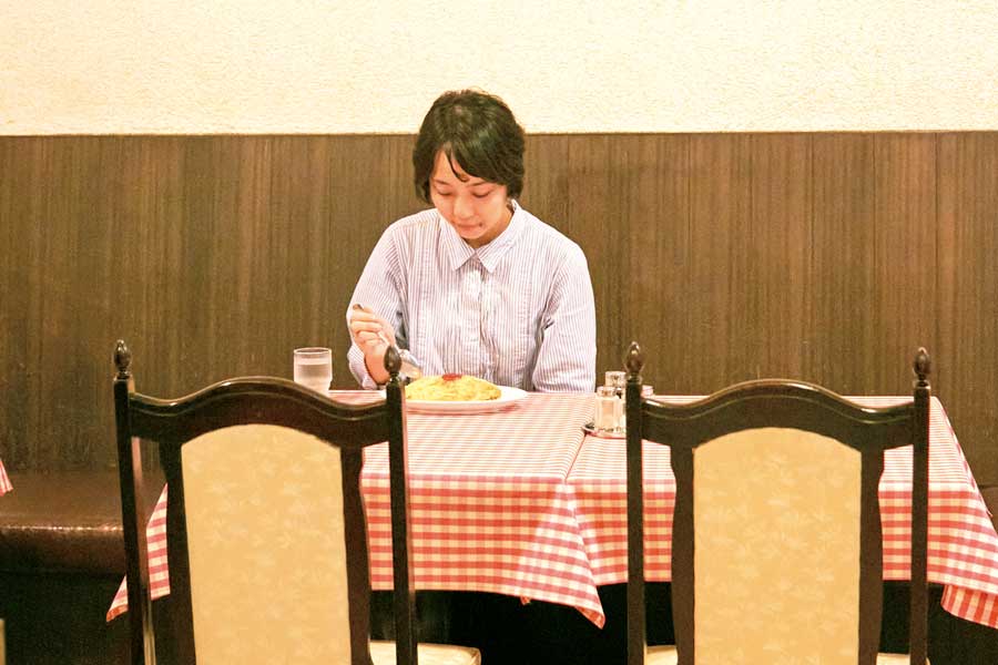 十字屋で料理を食べる女性