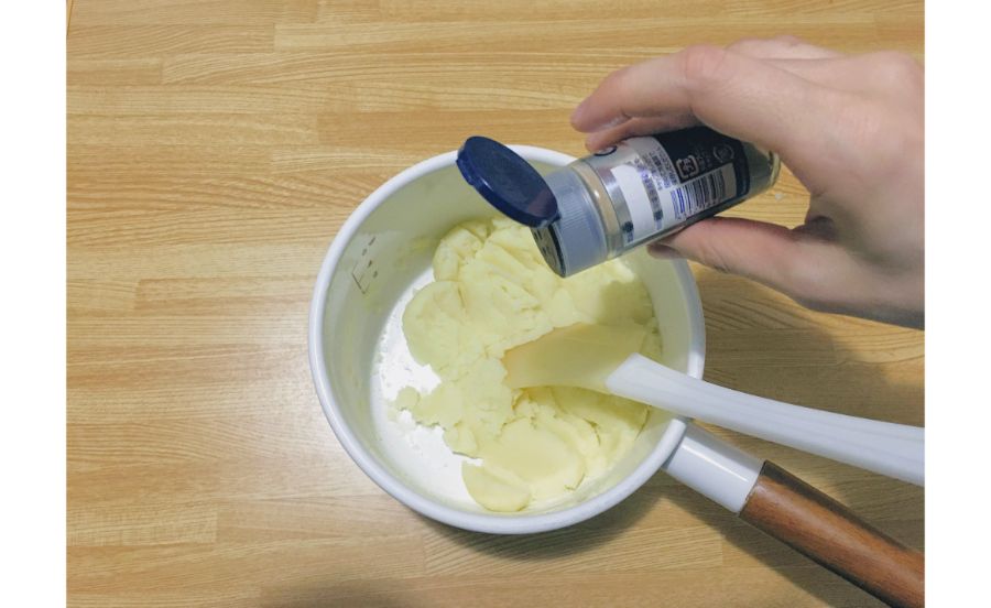 茹でたジャガイモにコショウを振っている