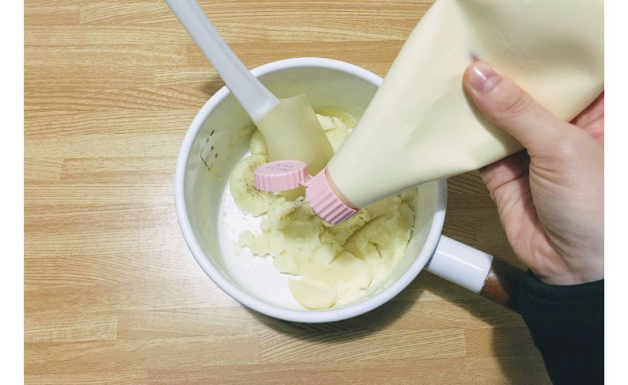 茹でたジャガイモにマヨネーズを入れている