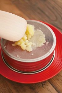 ポテトを裏ごしする手元