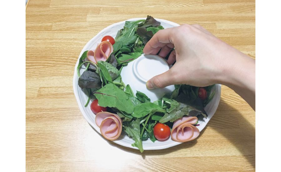 リースに見えるサラダを作っている