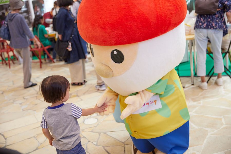 アロハシャツ姿のH2Oサンタと握手する子供