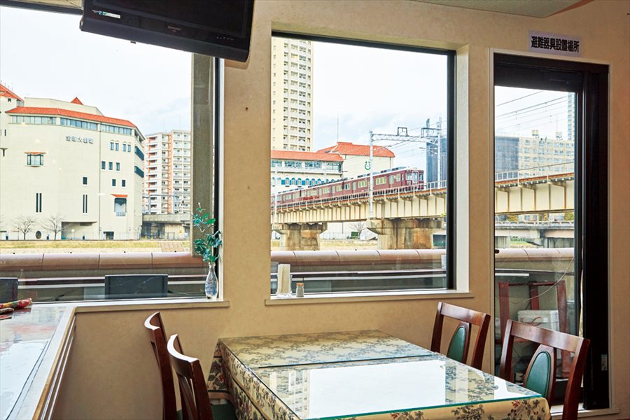 窓の外に阪急電車が見えるカロスキューマ