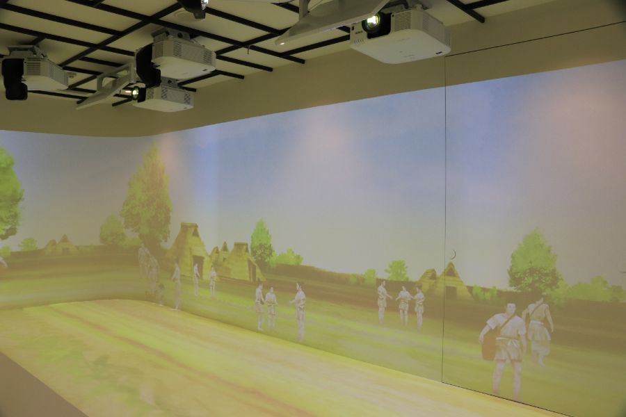 弥生時代の人々(イラスト)が映し出された映像