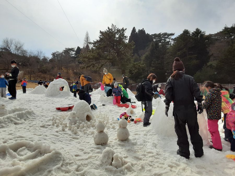 雪だるまを作る親子の姿