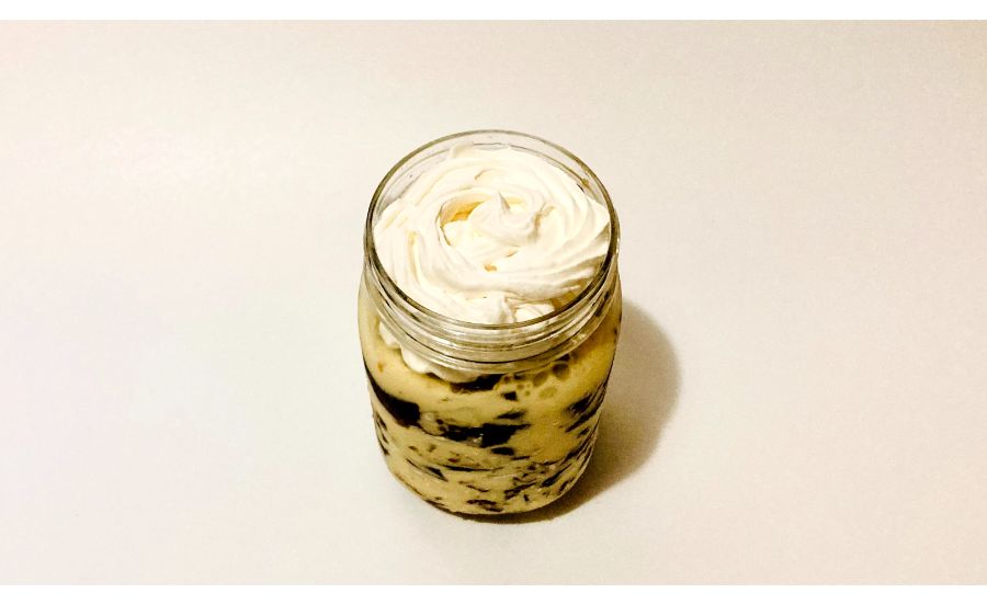 容器に入れたコーヒーゼリーとアイスクリームを蓋の手前まで何層にも重ねたものの上にホイップをしぼった状態