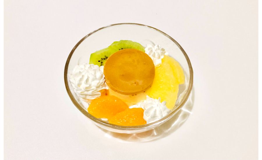 器に出した焼きプリンにホイップクリームを絞ったものにフルーツを盛り付けたもの