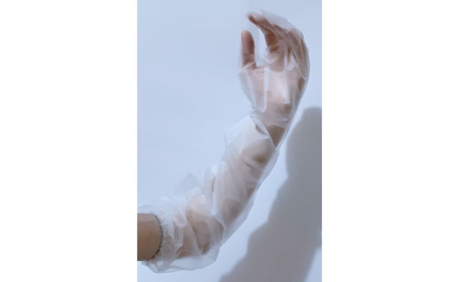 肘まで覆えるロングタイプポリエチレン使いきり手袋8枚入 クリアを腕にはめているところ