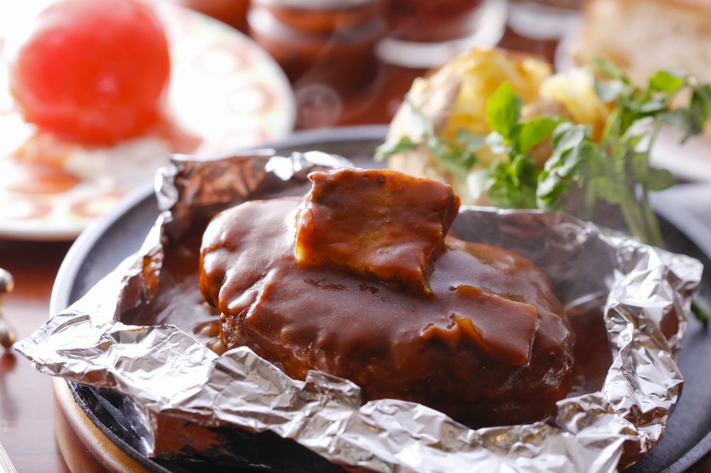 アルミホイルに包まれ、ビーフシチューがたっぷりかかったハンバーぐ