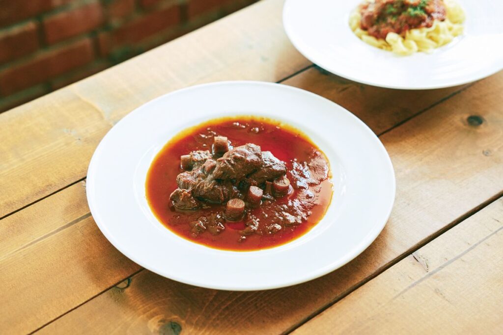 ｢鹿肉の赤ワイン煮込み｣ 手前 と｢イノシシのボロニェージェ｣奥