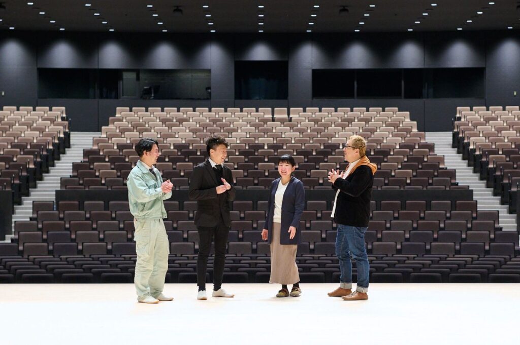 大ホールのステージで語らう4人
