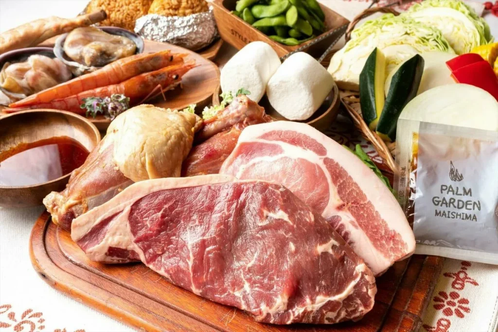 大きなステーキを囲むバーベキュー食材